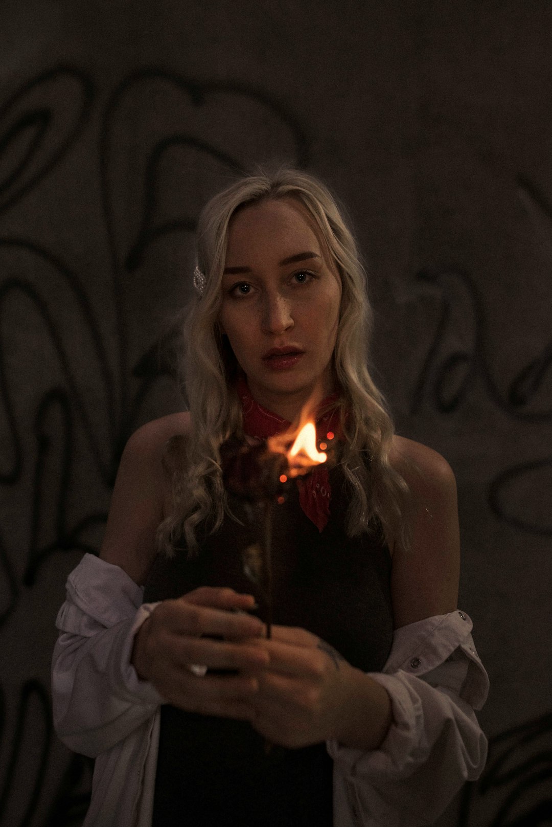 woman in white tank top holding lighted sparkler