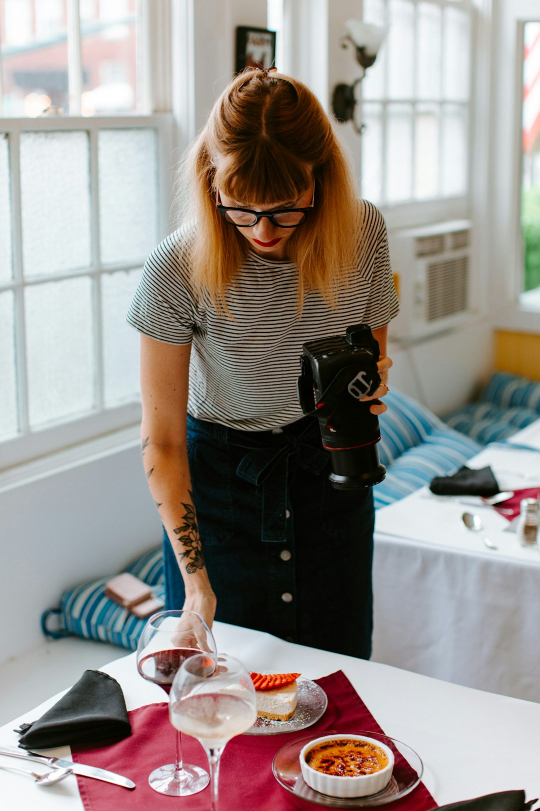 woman in black and white stripe shirt holding black dslr camera