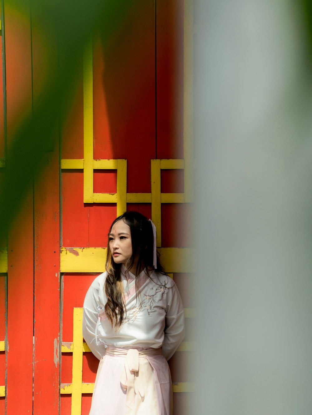 a woman standing in front of a red and yellow wall