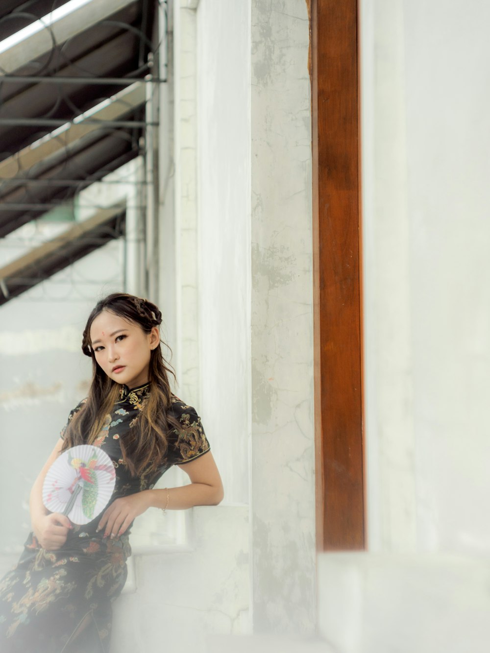 a woman standing next to a wall holding a frisbee