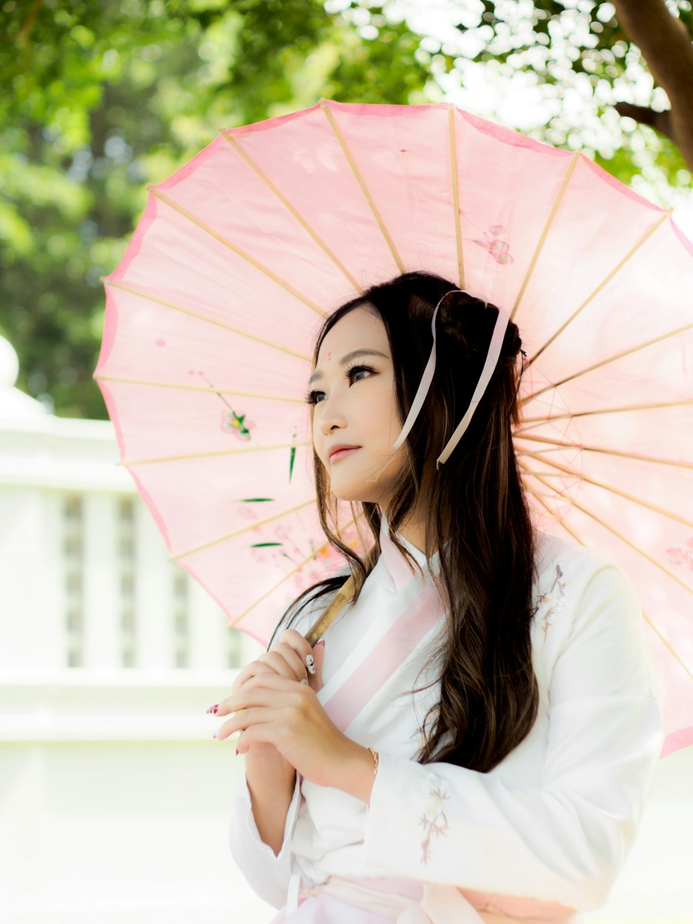 a woman in a kimono holding a pink umbrella