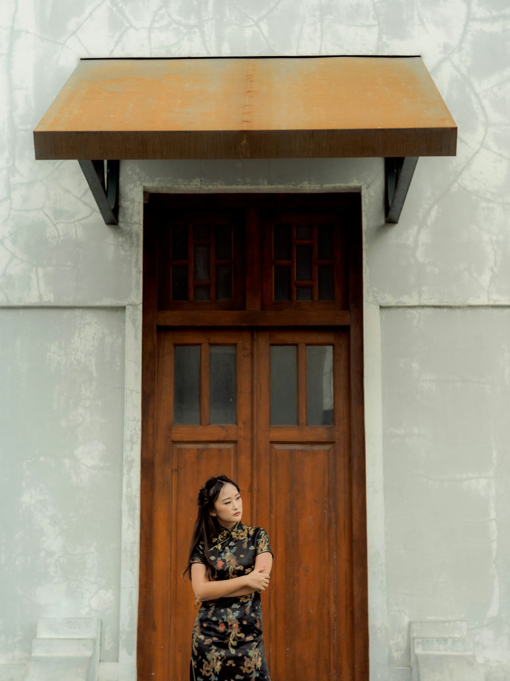 a woman standing in front of a wooden door