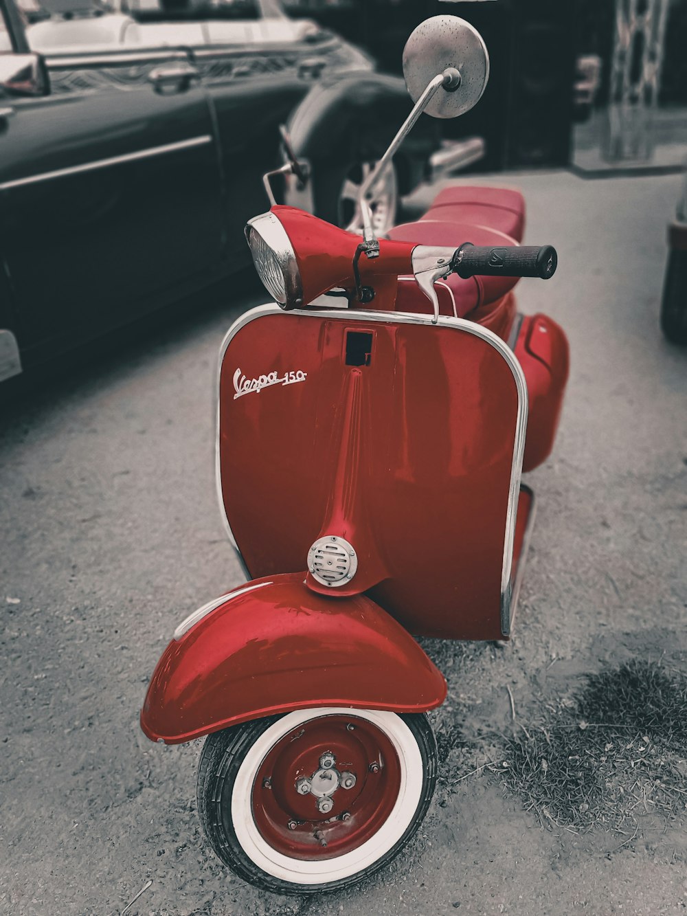 red and white motor scooter on gray asphalt road during daytime