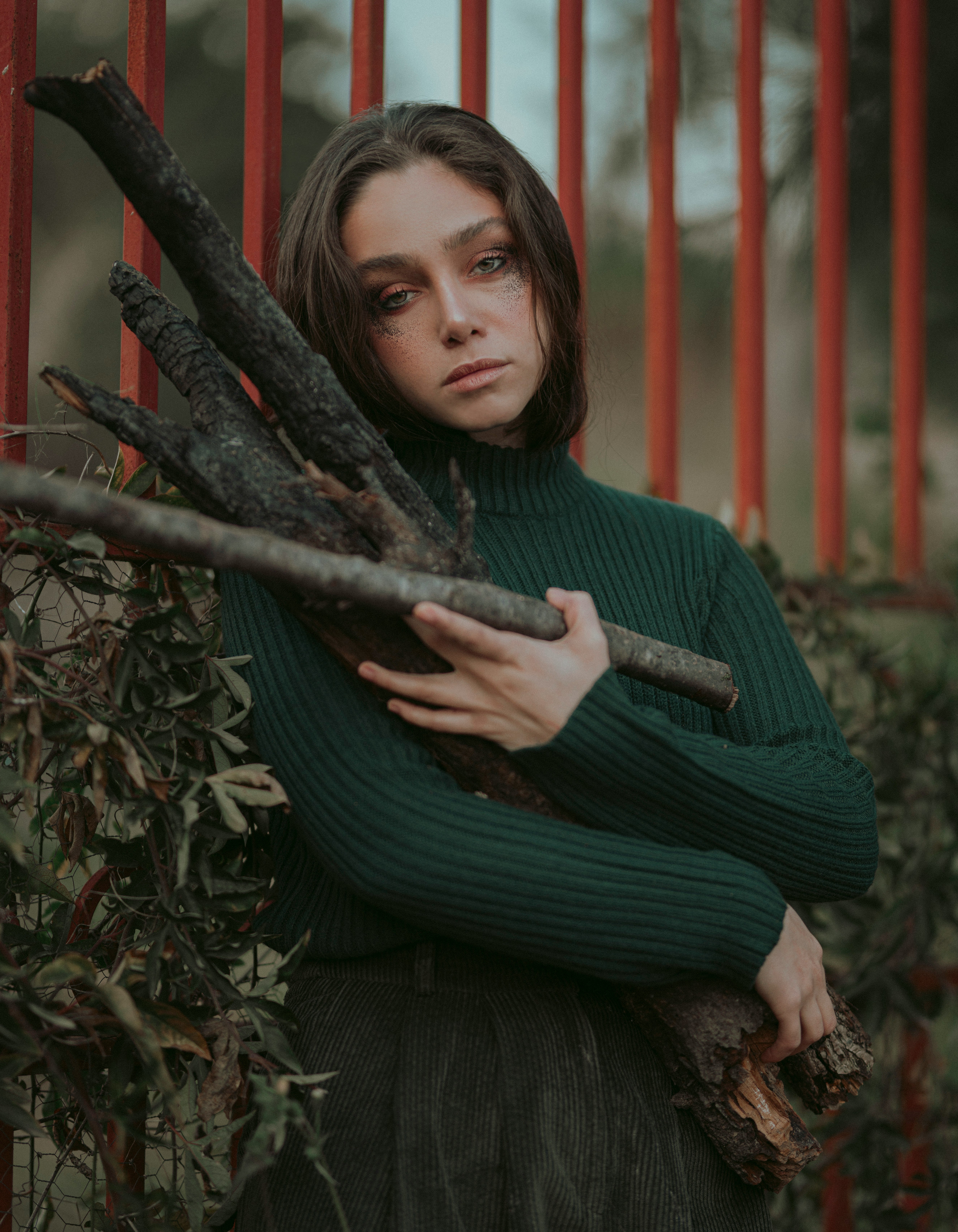 woman in green long sleeve shirt holding tree branch
