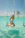 Smiling woman enjoying the turquoise waters of Saona Island with palm trees in the background
