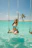 Smiling woman enjoying the turquoise waters of Saona Island with palm trees in the background
