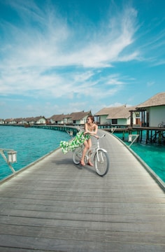 man in green shirt riding bicycle on dock during daytime