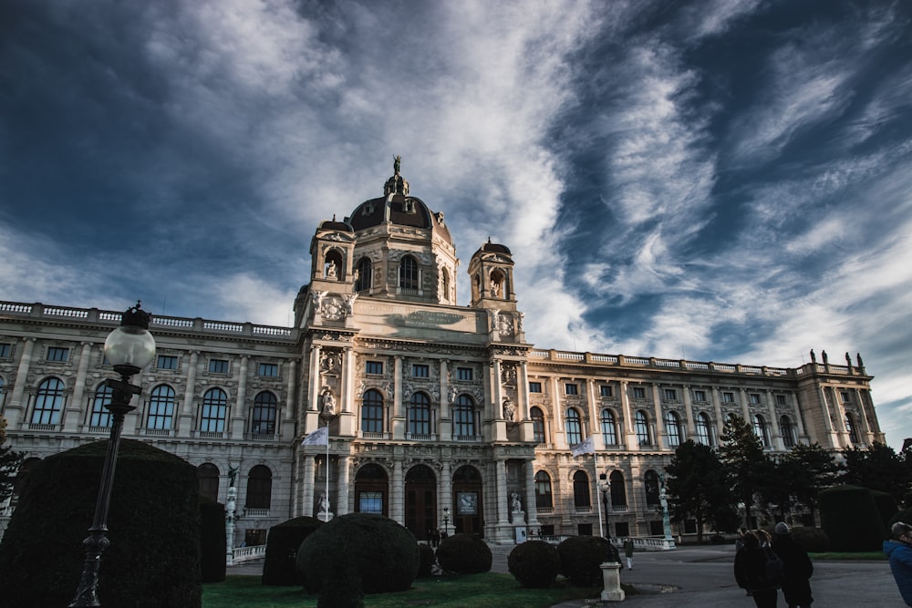 Braunes Betongebäude unter blauem Himmel und weißen Wolken tagsüber