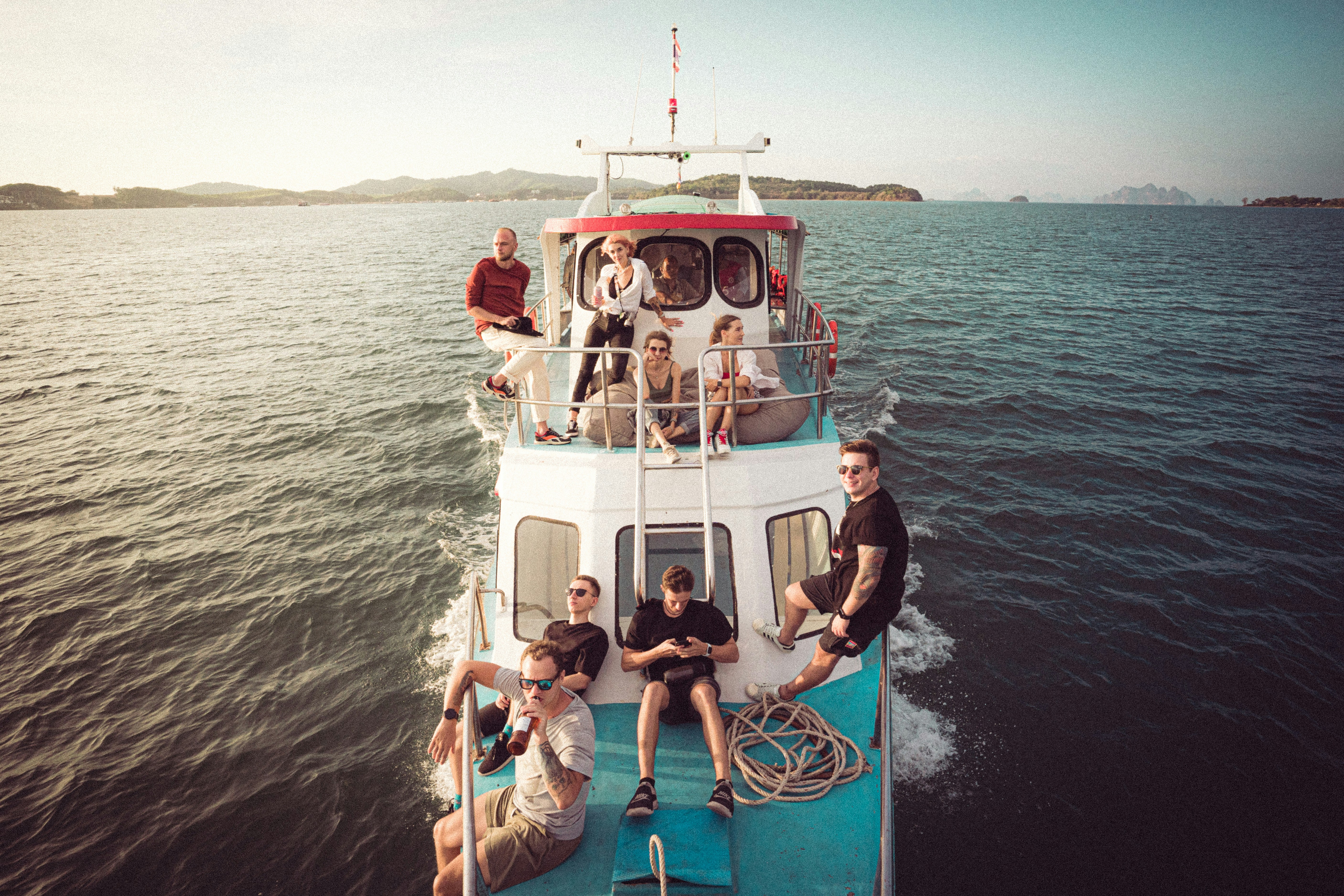 people riding on white and blue boat during daytime