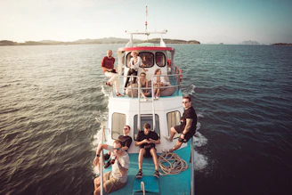 people riding on white and blue boat during daytime