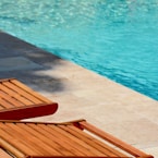 brown wooden chair near swimming pool during daytime