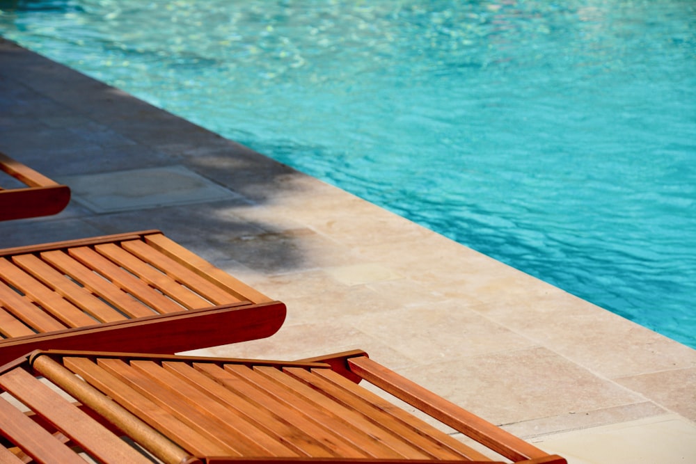 brown wooden chair near swimming pool during daytime