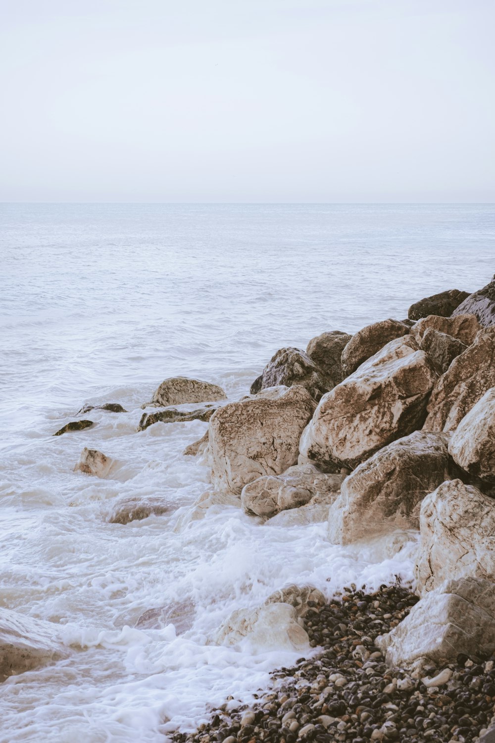 brown and gray rocks near body of water during daytime