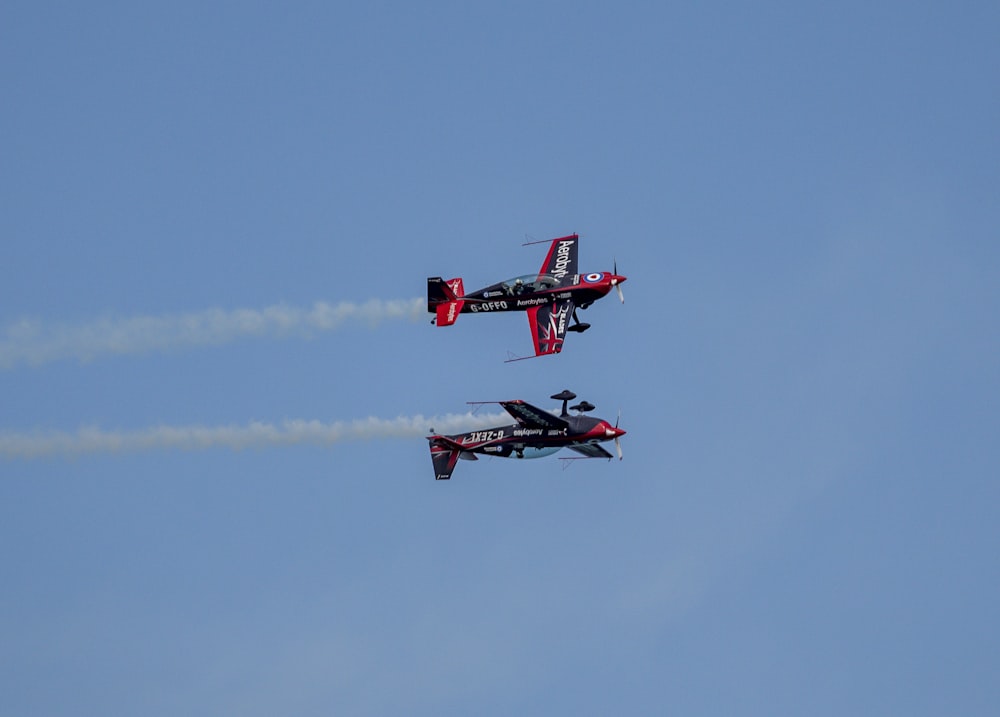 red and black jet plane in mid air during daytime