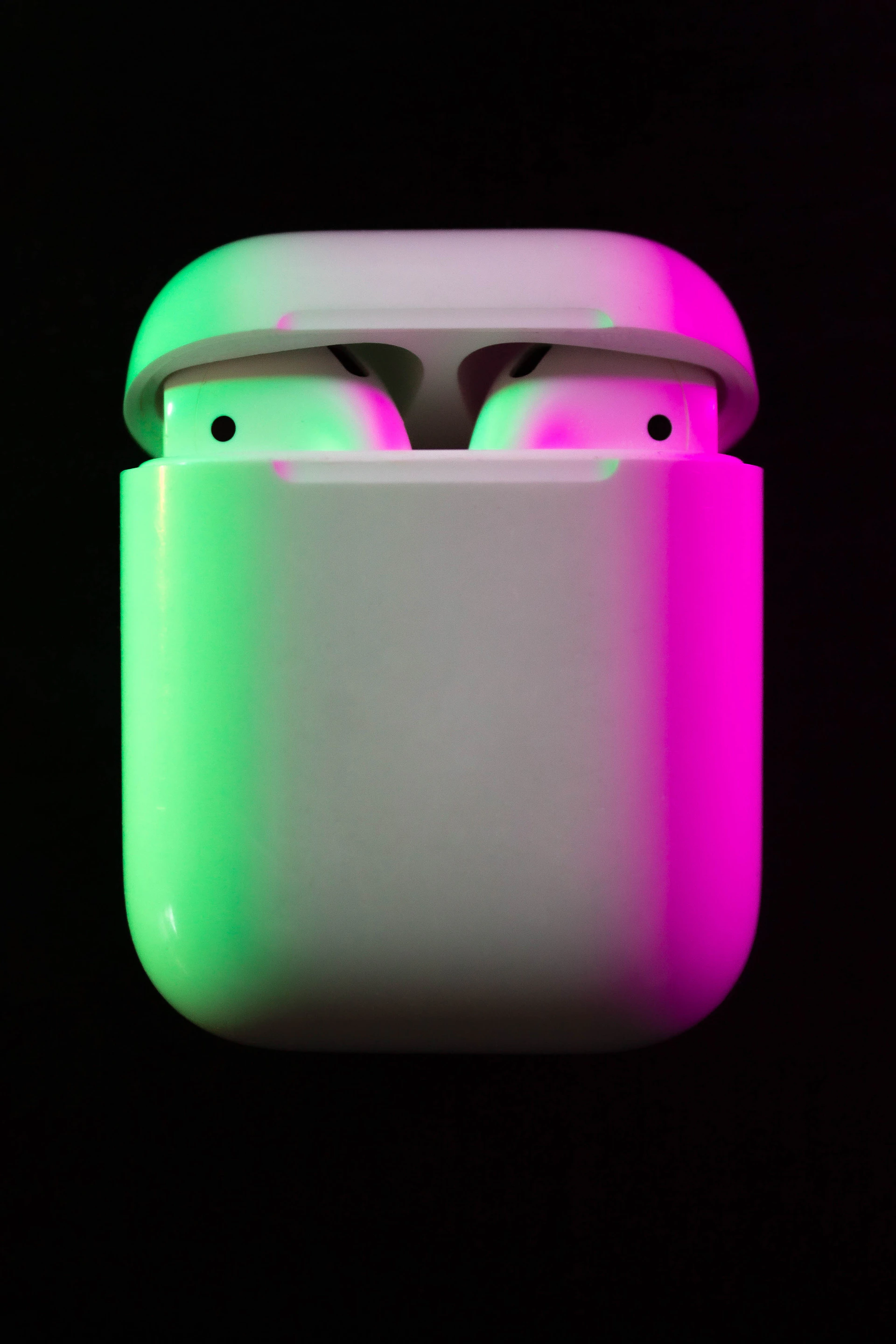 A vibrant display of compact, stylish wireless earbuds glowing softly against a dark backdrop with neon accents.