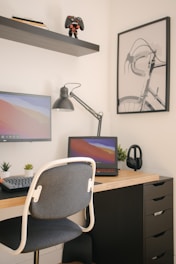 A clean and modern workspace with a laptop, smartphone, and bicycle helmet on a white desk.