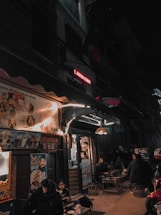 A cozy Parisian cafe terrace illuminated at night, inviting conversations.