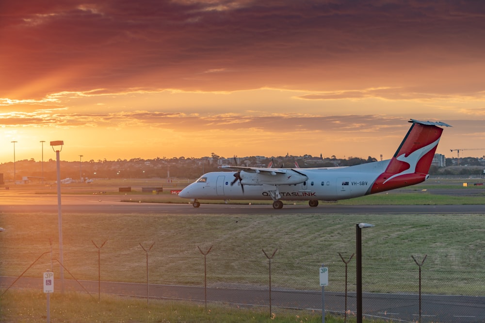 Weißes Passagierflugzeug am Flughafen bei Sonnenuntergang