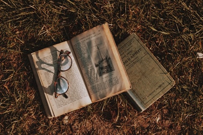 an open book with a pair of glasses on top of it
