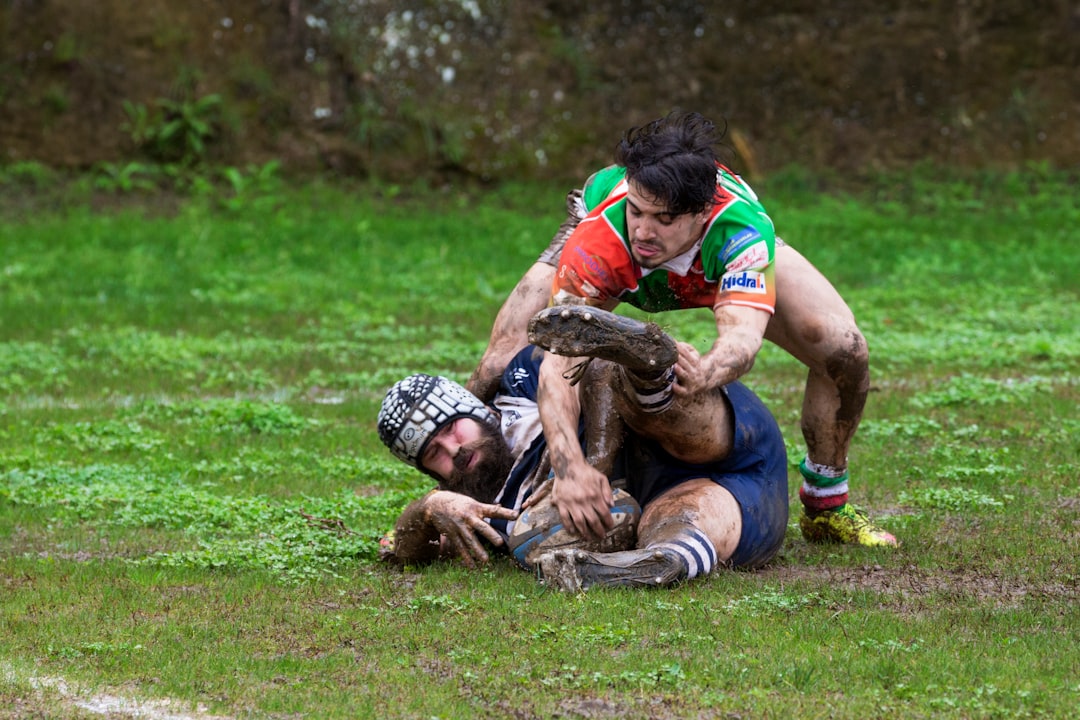 man in blue shorts lying on green grass field