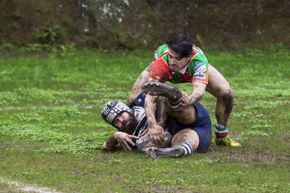 man in blue shorts lying on green grass field