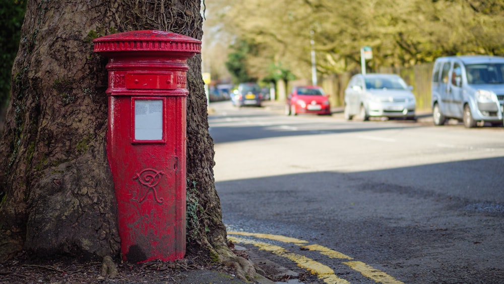 昼間の道路上の赤い郵便ポスト