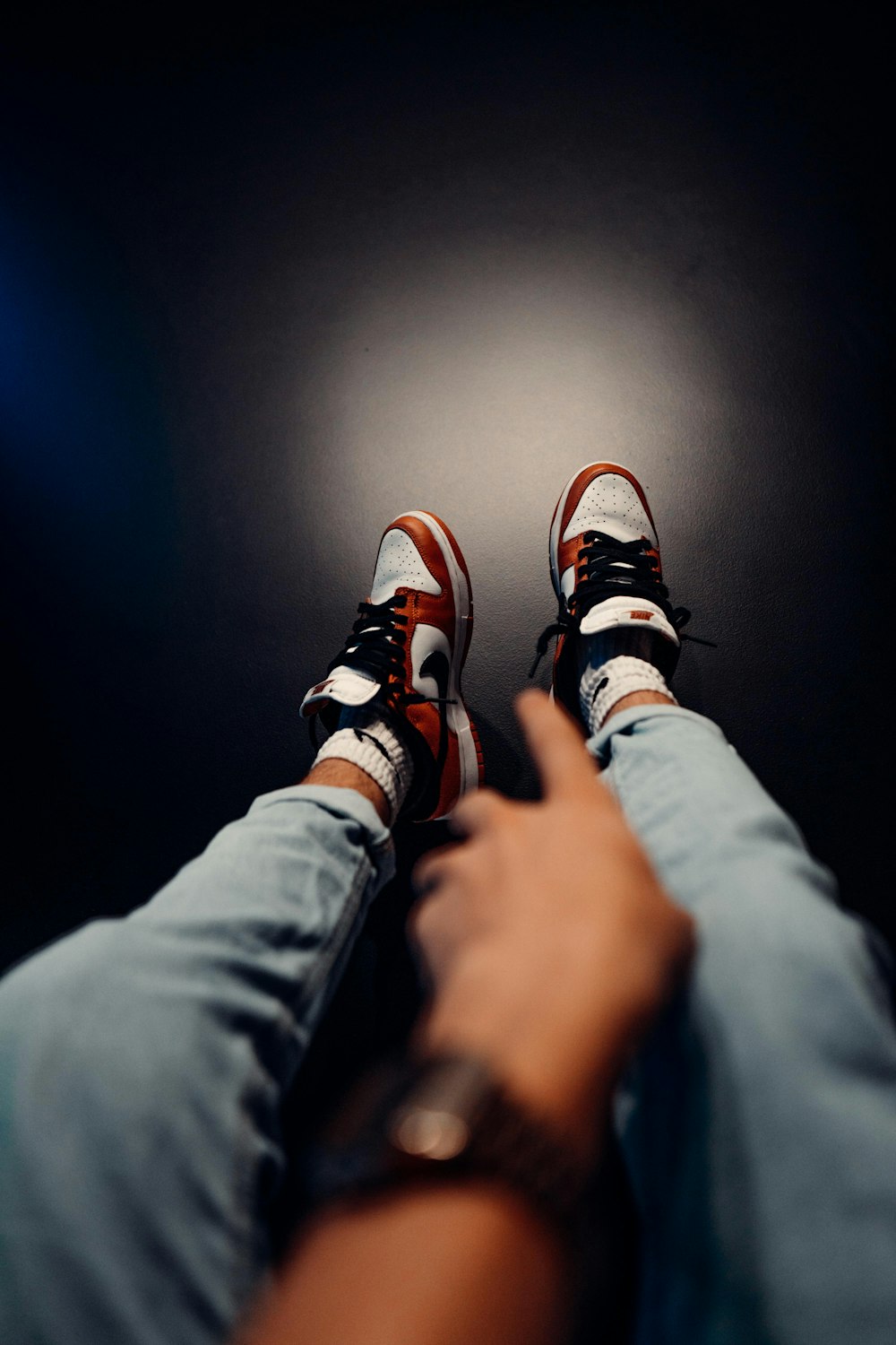 person in black pants wearing black and orange sneakers