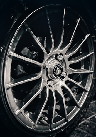 Detail shot of a polished alloy wheel with intricate design and deep charcoal finish.