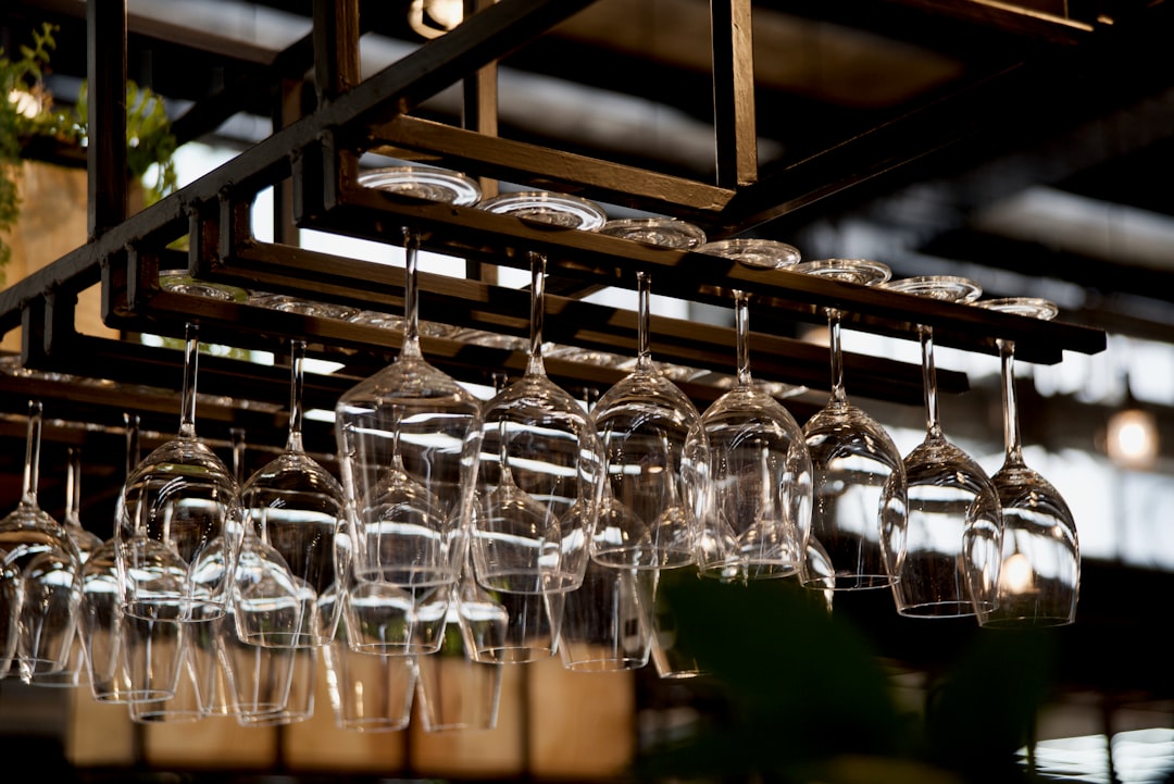 clear drinking glasses on brown wooden shelf