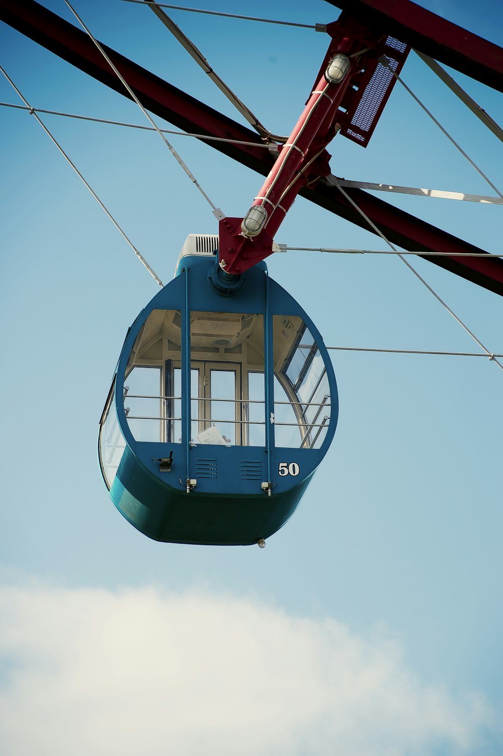 blue and red cable car under blue sky during daytime