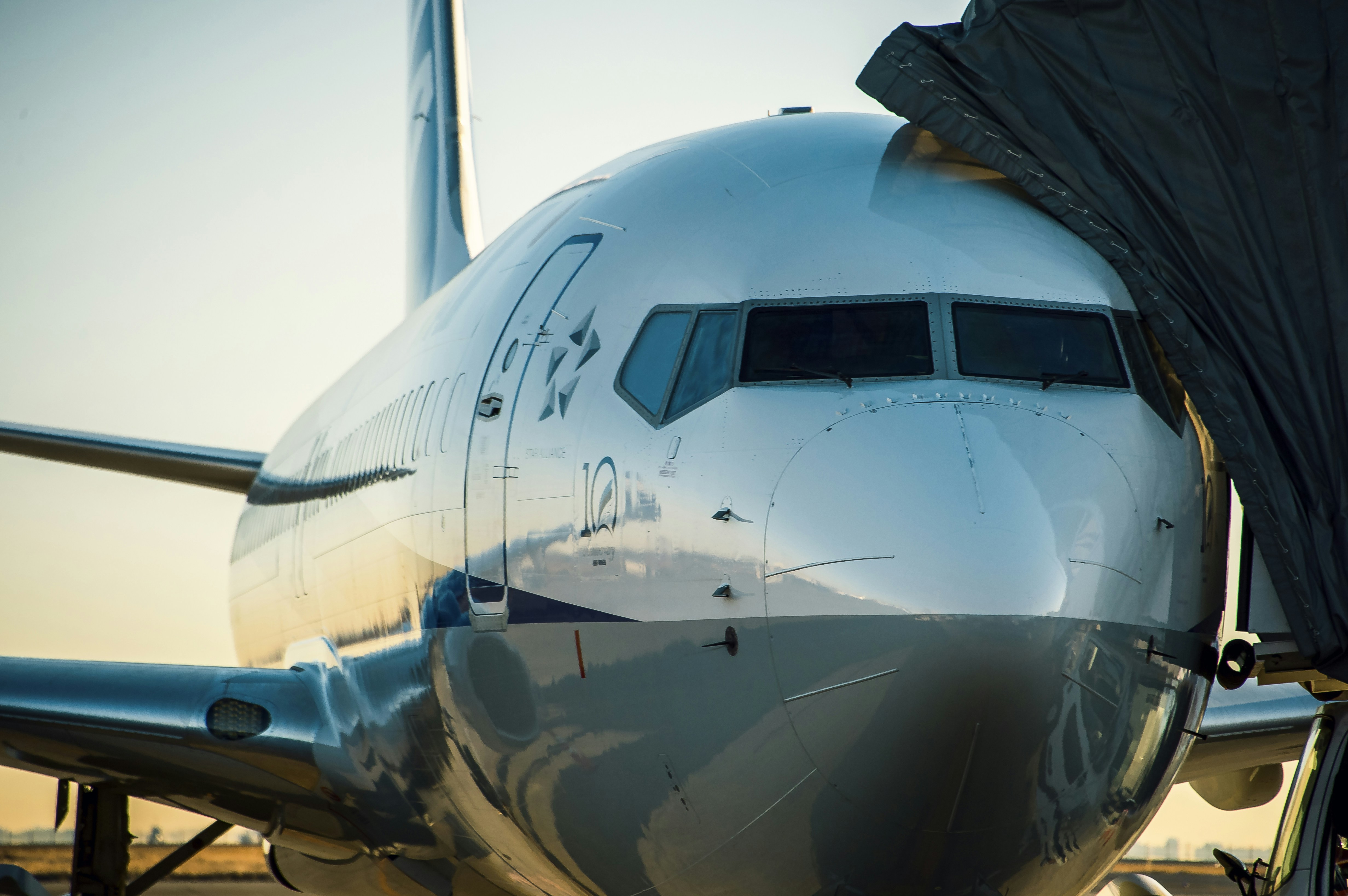 white and blue airplane under blue sky during daytime