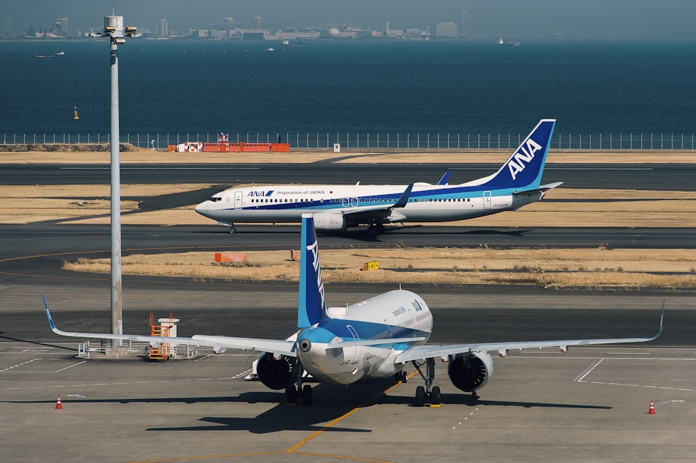 white and blue airplane on airport during daytime