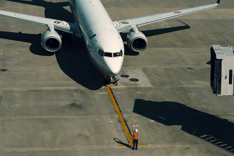 White and blue airplane on airport tarmac during daytime