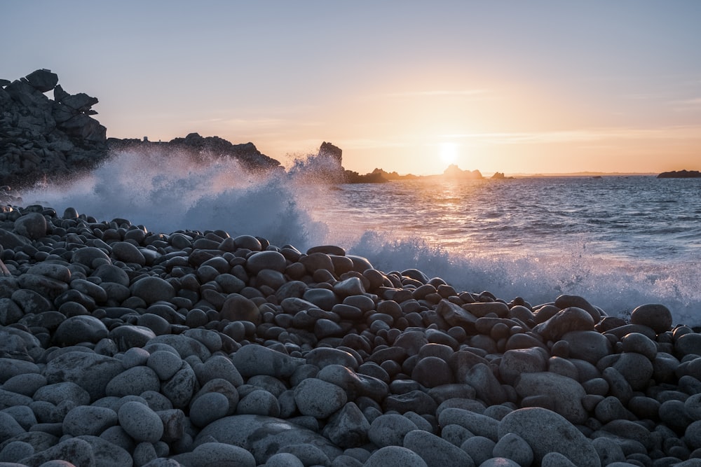 gray rocks near sea waves during daytime