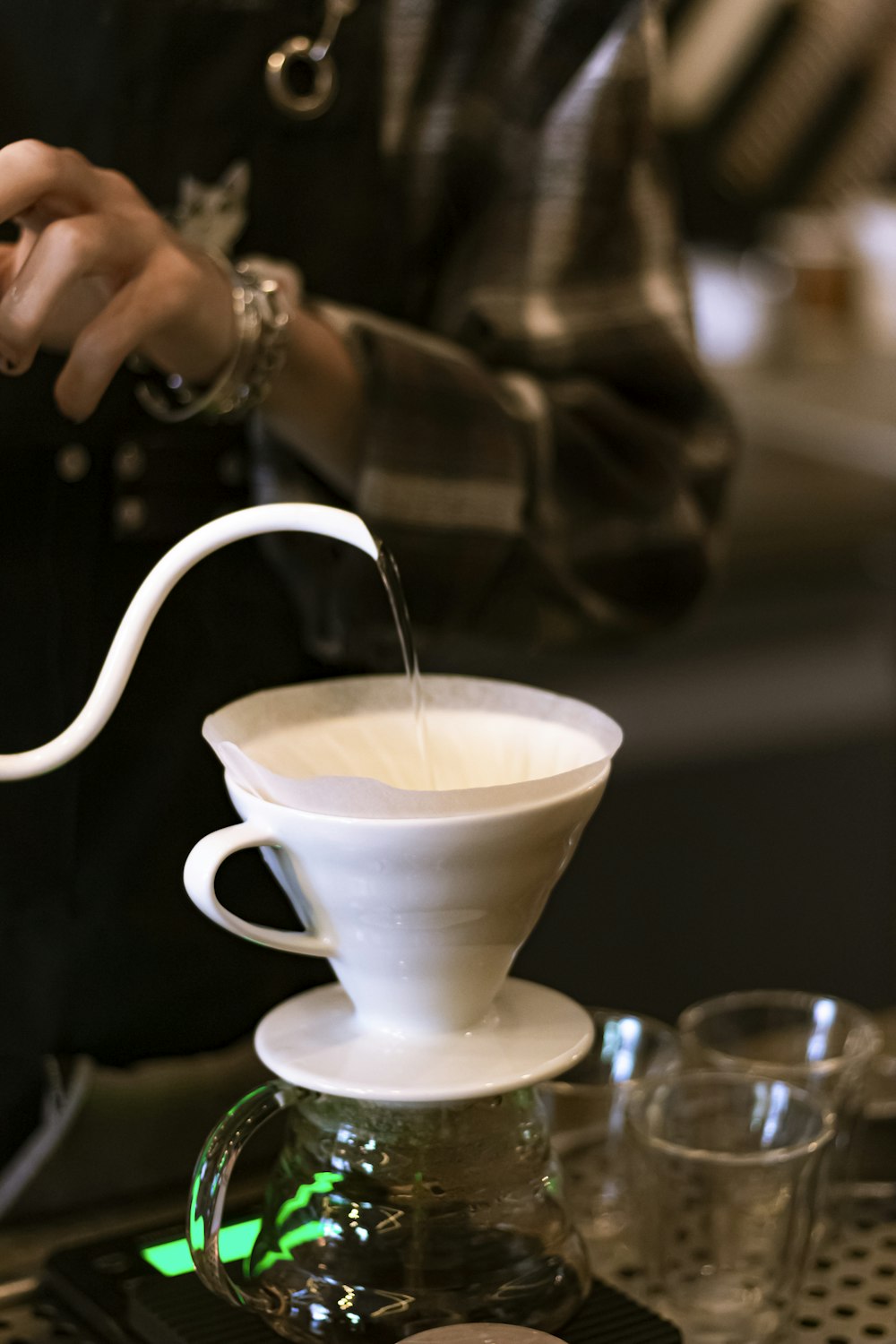 person pouring white ceramic teacup on white ceramic saucer