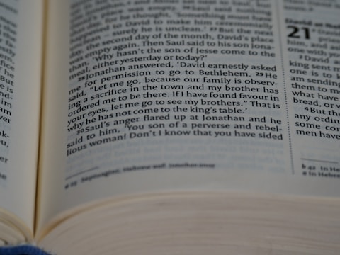 A close-up view of an open book with printed text in English. The text appears to be from a section or chapter, as indicated by a large bold number to the right. The book has visible lines of text with a focus on certain verses or passages.