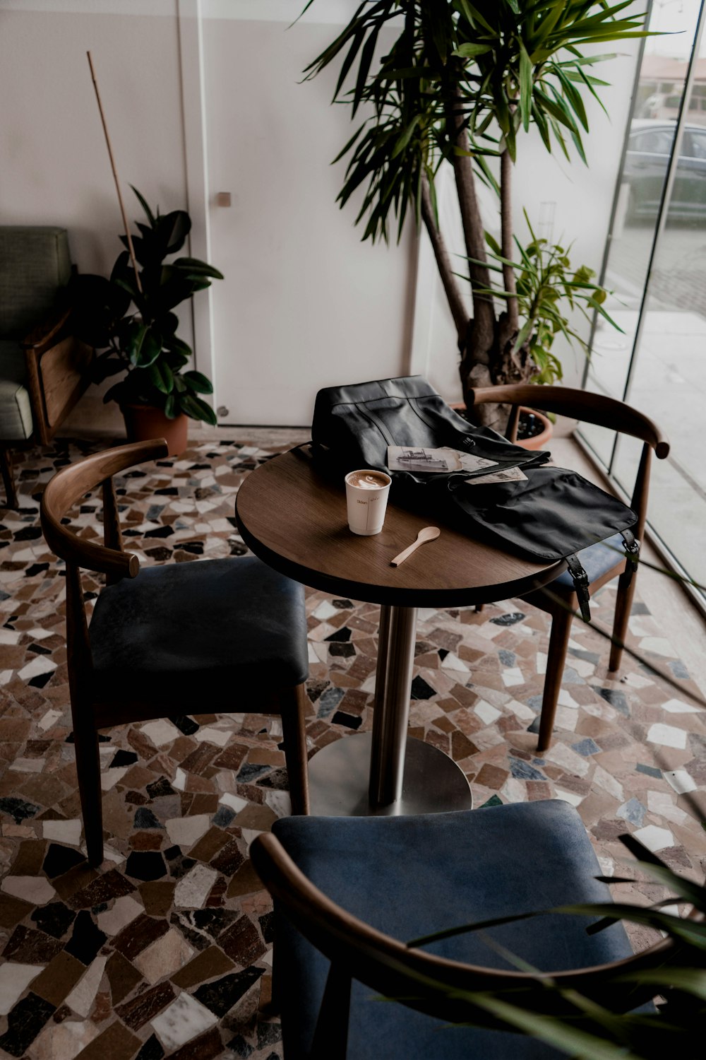 Sac en cuir noir sur table ronde en bois marron