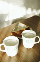 A cozy family moment with puzzle mugs on a wooden table, sunlight streaming in.