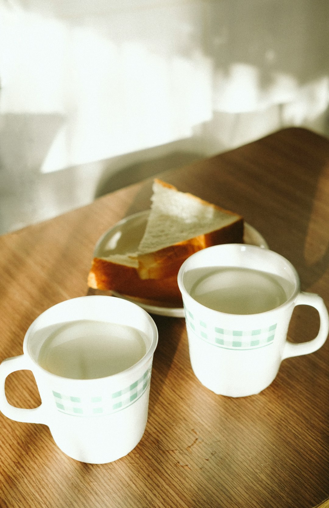 white ceramic mug on brown wooden table