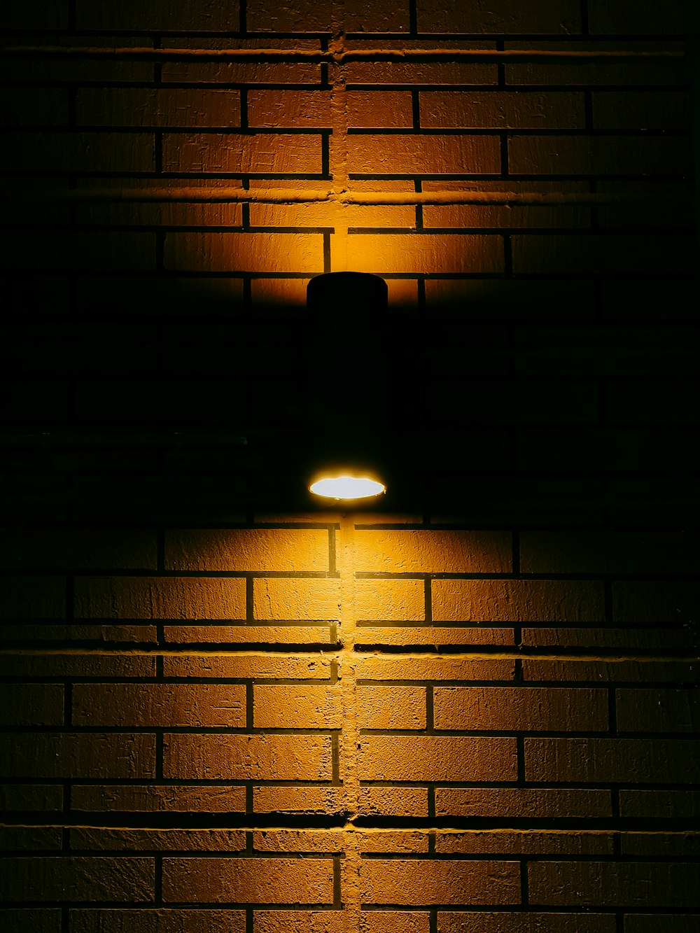 black pendant lamp turned on in dark room