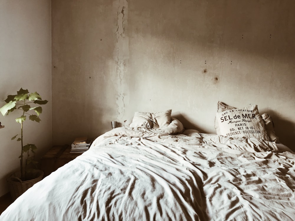 white and black throw pillow on white bed