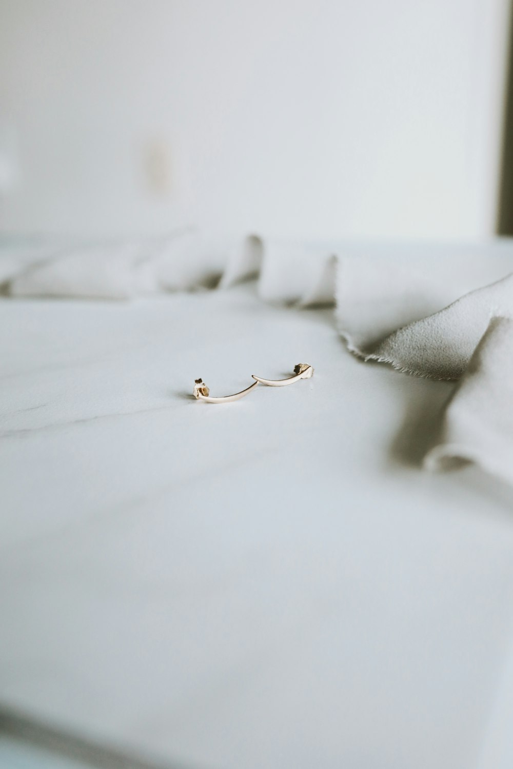 gold ring on white textile