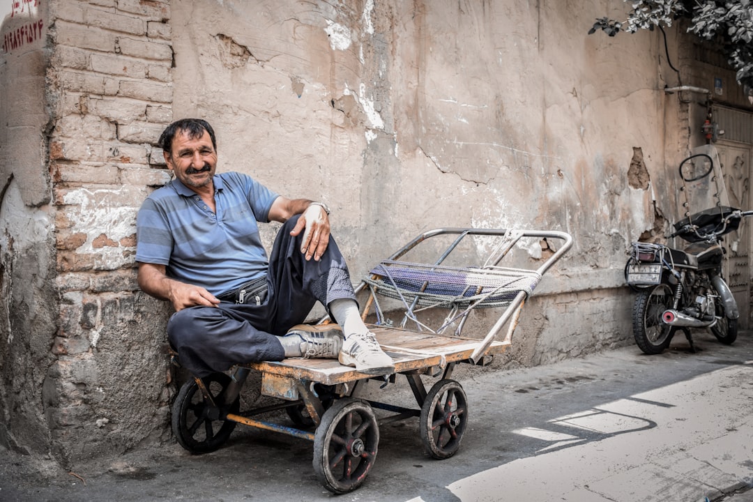 man in blue dress shirt sitting on black wheel chair