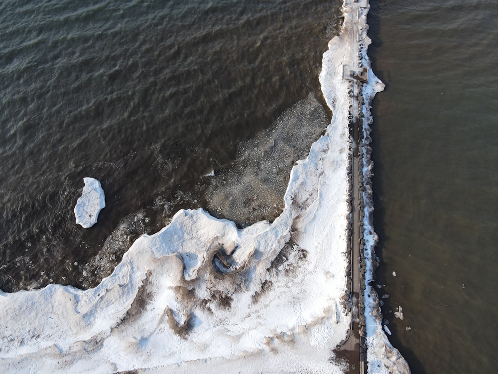 aerial view of ocean waves crashing on shore during daytime