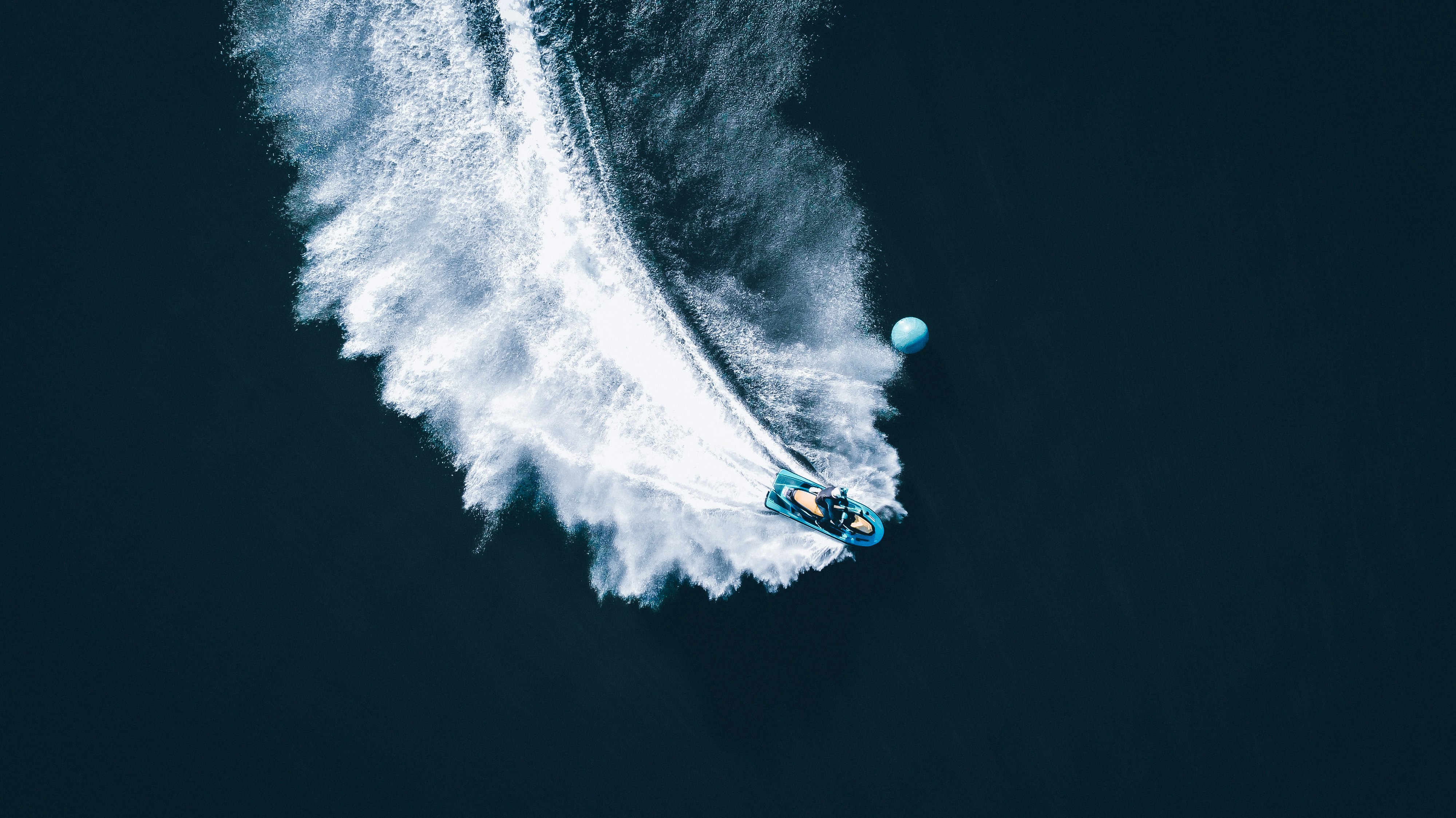 person in blue and white hoodie riding on blue and white boat on water