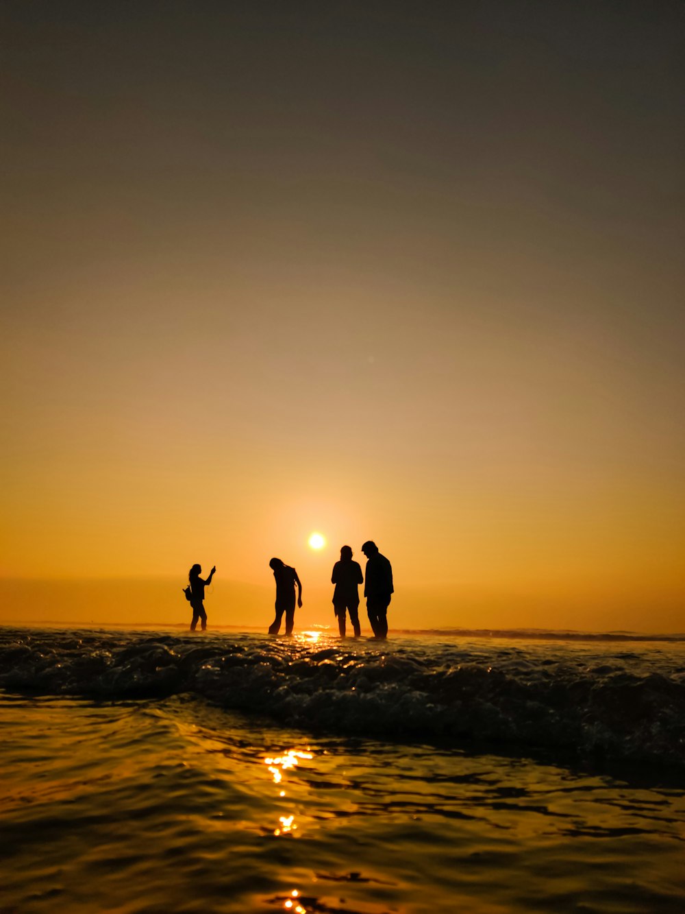 silhouette of people on beach during sunset