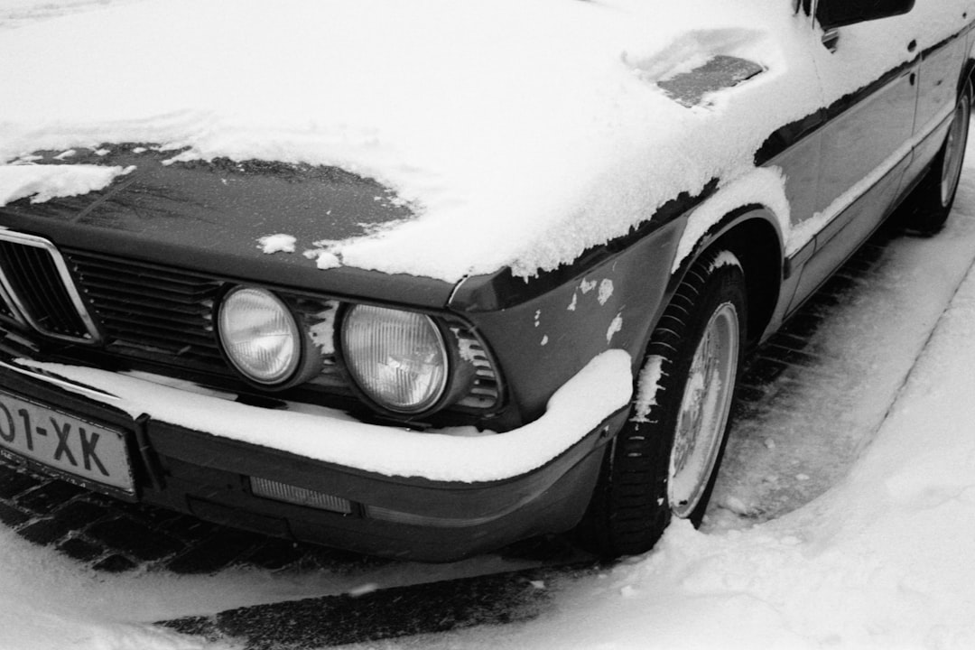 grayscale photo of car covered with snow