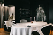 Elegant dining room with matte black walls, ivory table settings, and subtle gold details.