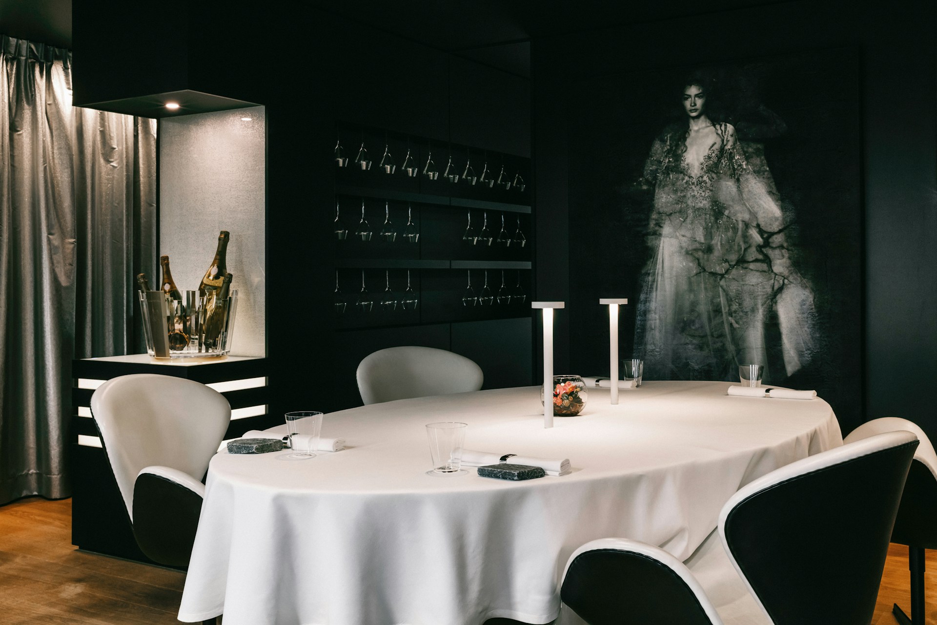 An elegant dining area with a minimalist table set against a backdrop of artistic wall decor.