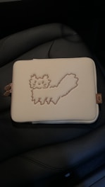 A cozy cotton pouch personalized with a cat photo, resting on a soft cream fabric background.